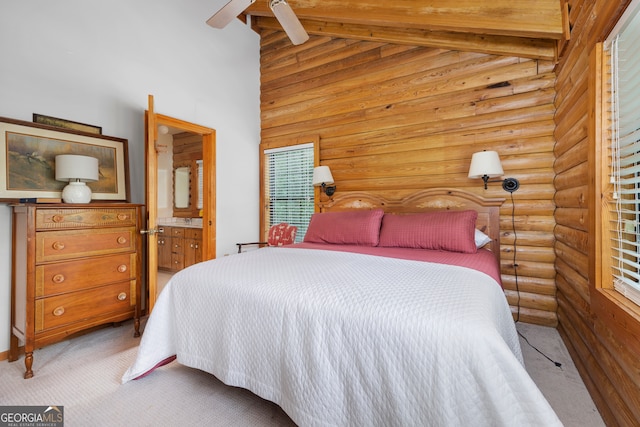 carpeted bedroom featuring high vaulted ceiling, ceiling fan, and ensuite bathroom