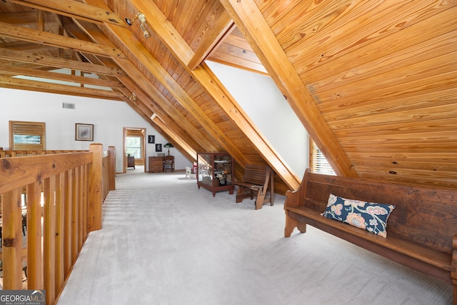 interior space featuring lofted ceiling with beams, plenty of natural light, and carpet floors