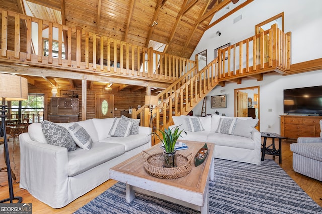 living room with beamed ceiling, wood-type flooring, wood ceiling, high vaulted ceiling, and wooden walls