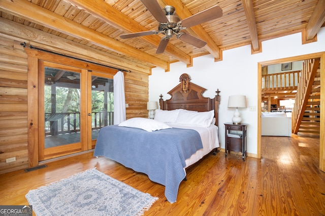 bedroom with access to outside, hardwood / wood-style floors, ceiling fan, and rustic walls