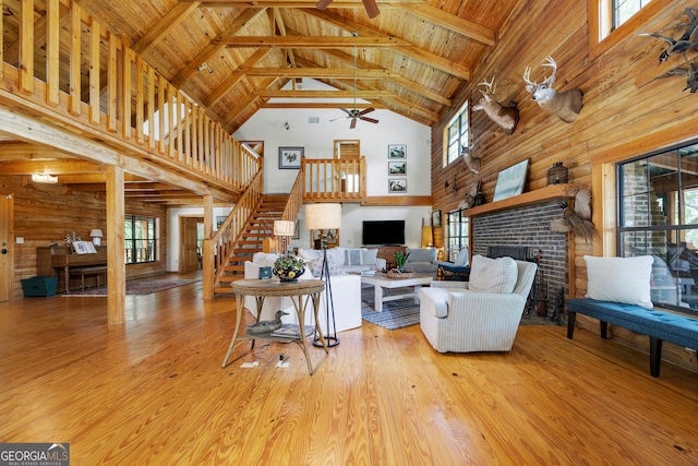 living room with high vaulted ceiling, plenty of natural light, and light hardwood / wood-style floors