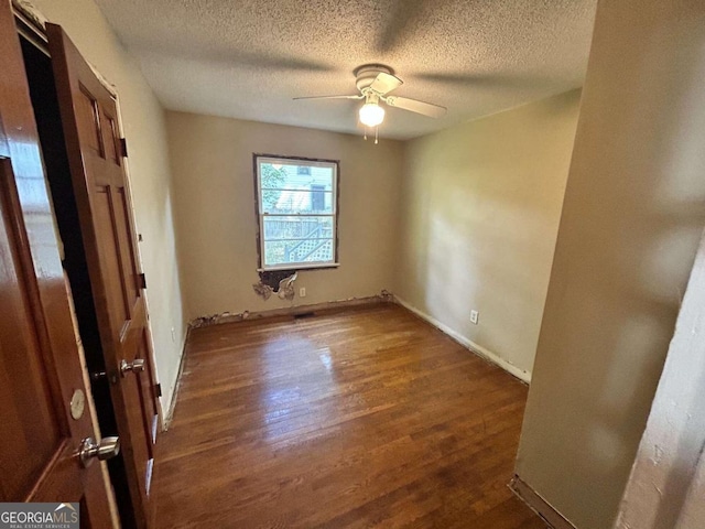 unfurnished room with dark hardwood / wood-style floors, a textured ceiling, and ceiling fan