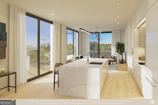 interior space featuring floor to ceiling windows, plenty of natural light, and sink