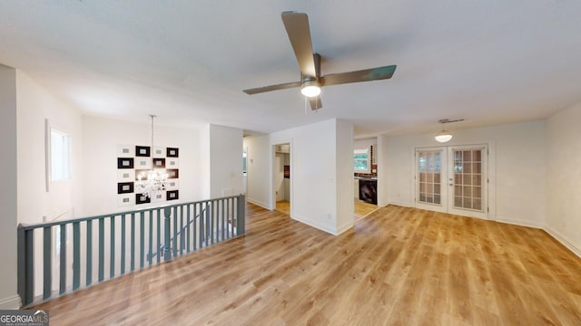 spare room with light hardwood / wood-style flooring, ceiling fan, and french doors