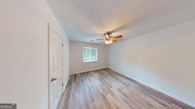 empty room featuring light wood-type flooring and ceiling fan