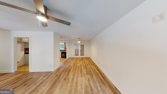 unfurnished living room with ceiling fan and light hardwood / wood-style flooring