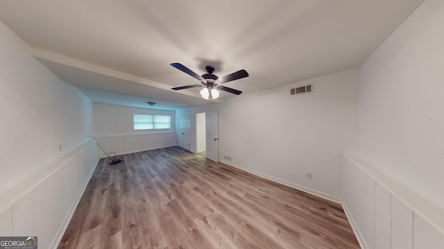 empty room with light wood-type flooring, visible vents, and a ceiling fan