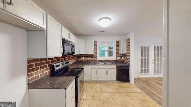 kitchen with light tile patterned flooring, black appliances, white cabinetry, tasteful backsplash, and sink