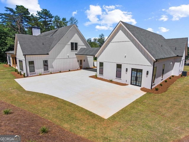 rear view of property featuring a lawn