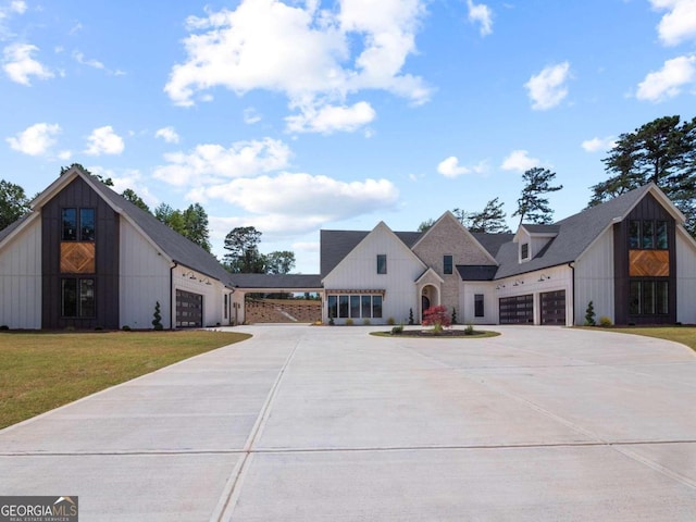 modern farmhouse with a front yard and a garage