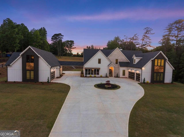 modern farmhouse featuring a garage and a lawn