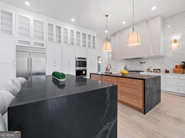 kitchen featuring white cabinetry, a center island, pendant lighting, decorative backsplash, and appliances with stainless steel finishes