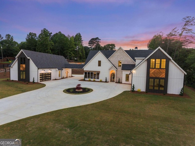 modern farmhouse featuring a yard and a garage