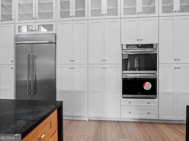 kitchen with white cabinets, dark stone counters, and appliances with stainless steel finishes