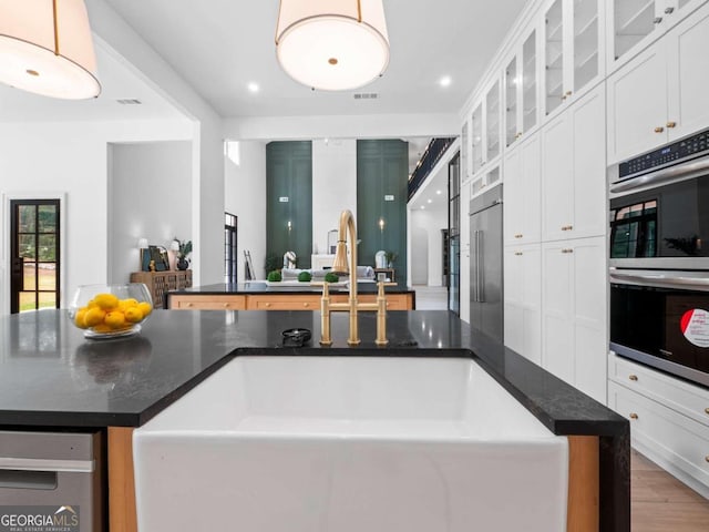 kitchen featuring pendant lighting, white cabinetry, sink, and stainless steel appliances