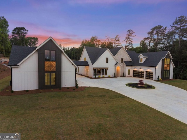 modern inspired farmhouse with a yard and a garage