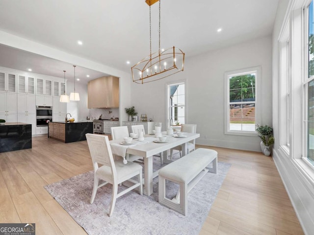 dining room with light hardwood / wood-style floors and an inviting chandelier