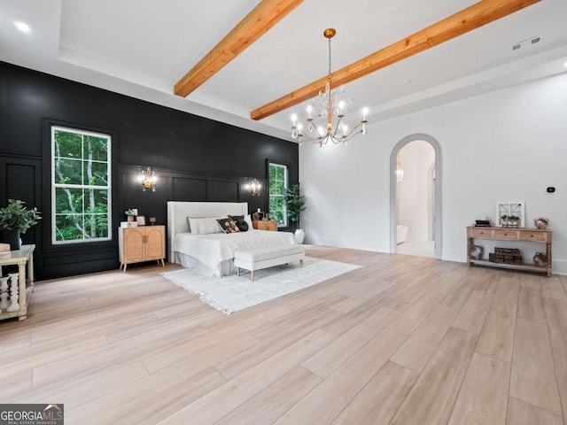 bedroom featuring light hardwood / wood-style floors, beam ceiling, and an inviting chandelier