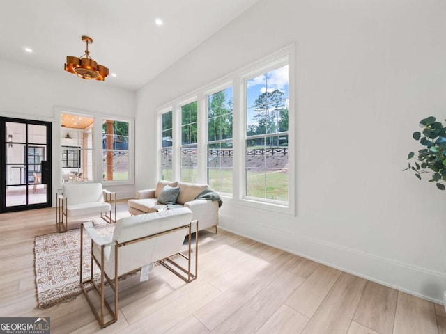 sunroom / solarium featuring a chandelier