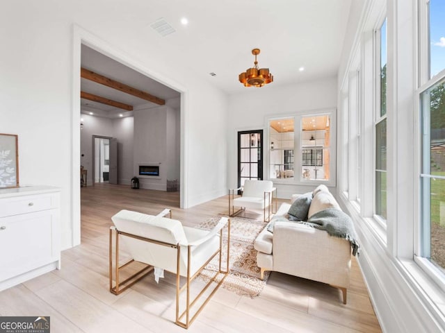 living room featuring light hardwood / wood-style flooring and beamed ceiling