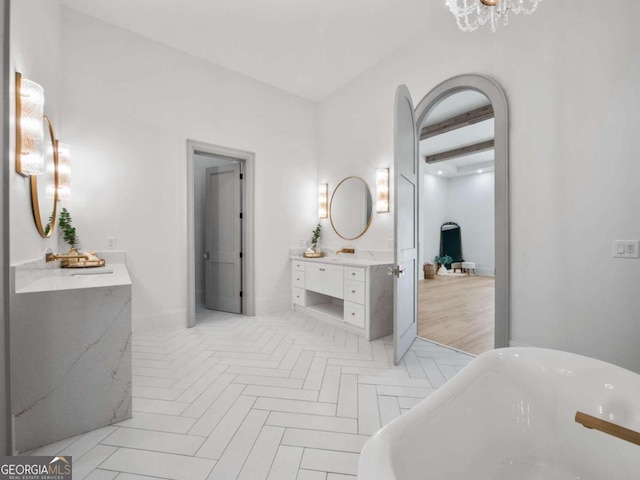 bathroom featuring a bathing tub, vanity, and parquet floors