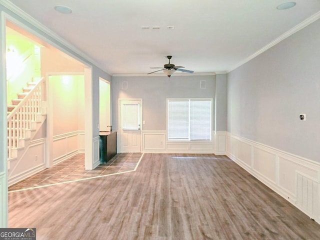 unfurnished living room featuring ceiling fan, crown molding, and hardwood / wood-style floors