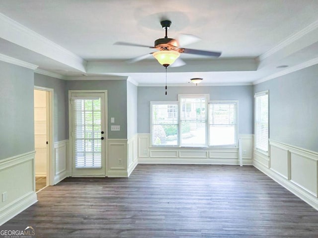 interior space with dark wood-type flooring, ceiling fan, crown molding, and a tray ceiling