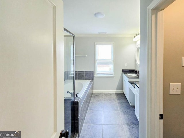 bathroom featuring a relaxing tiled tub, tile patterned floors, and vanity