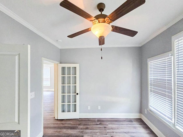 spare room with a wealth of natural light, crown molding, and wood-type flooring