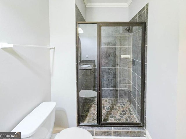 bathroom with toilet, crown molding, and walk in shower