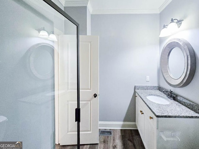 bathroom with hardwood / wood-style floors, vanity, and ornamental molding