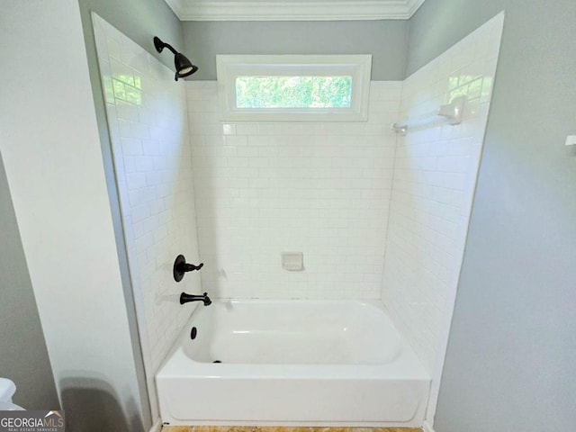 bathroom with crown molding and tiled shower / bath combo