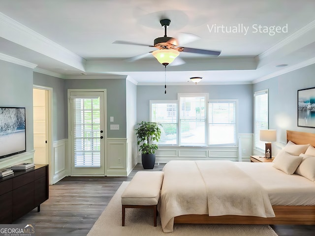 bedroom featuring ceiling fan, access to exterior, dark hardwood / wood-style flooring, and a tray ceiling