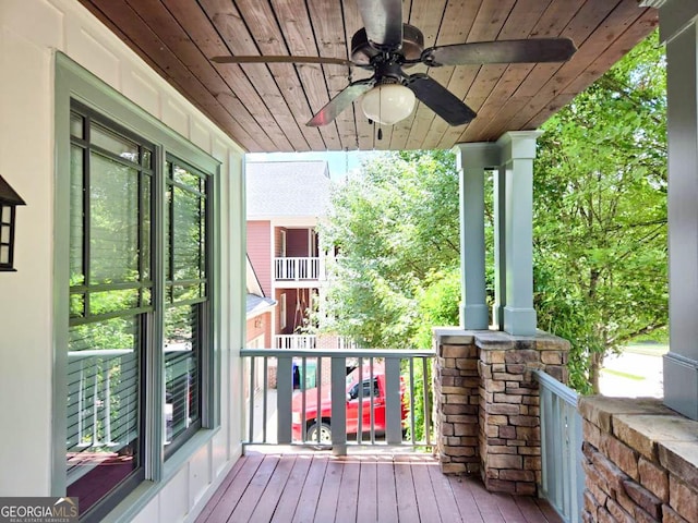 wooden terrace with ceiling fan and a porch