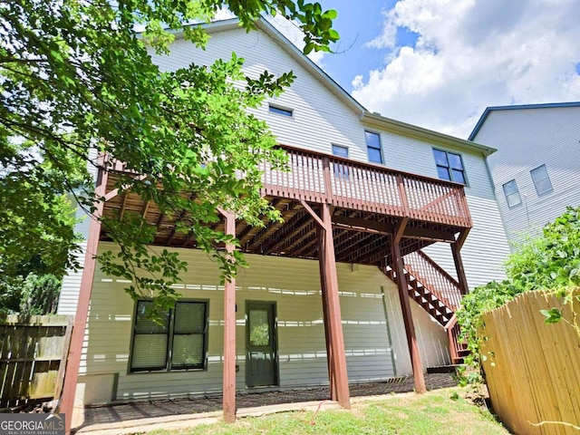 rear view of house featuring a wooden deck