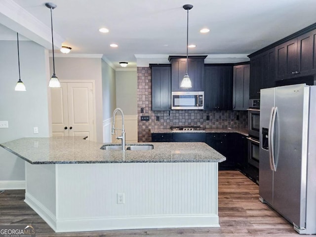 kitchen with pendant lighting, stainless steel appliances, tasteful backsplash, sink, and light stone counters