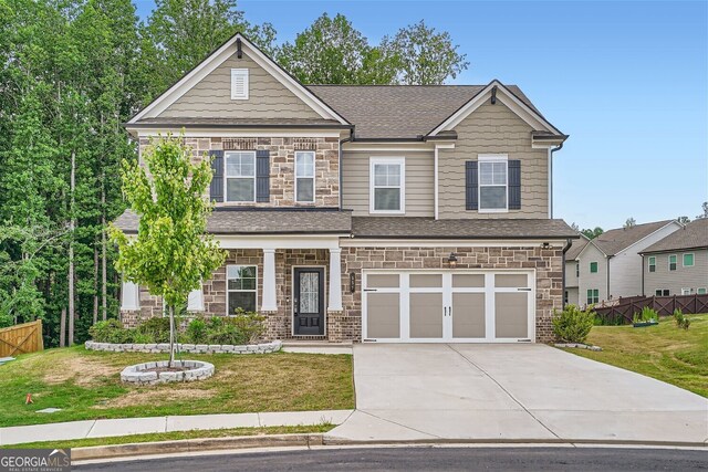 craftsman-style home featuring a garage and a front yard