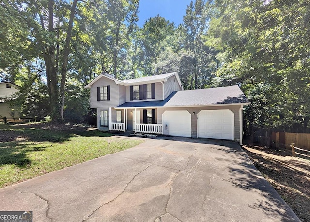 front of property featuring a garage, a front yard, and covered porch