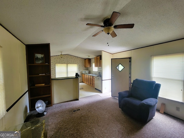 unfurnished room with a textured ceiling, ceiling fan, light colored carpet, and vaulted ceiling