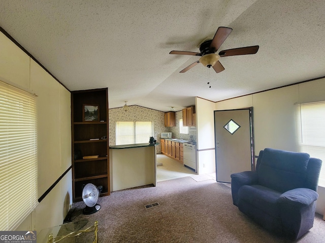 unfurnished living room with a textured ceiling, ceiling fan, lofted ceiling, and light carpet