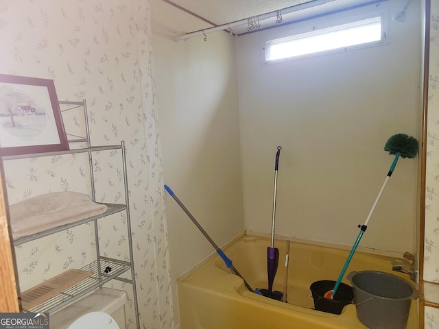 bathroom featuring shower / tub combination and toilet