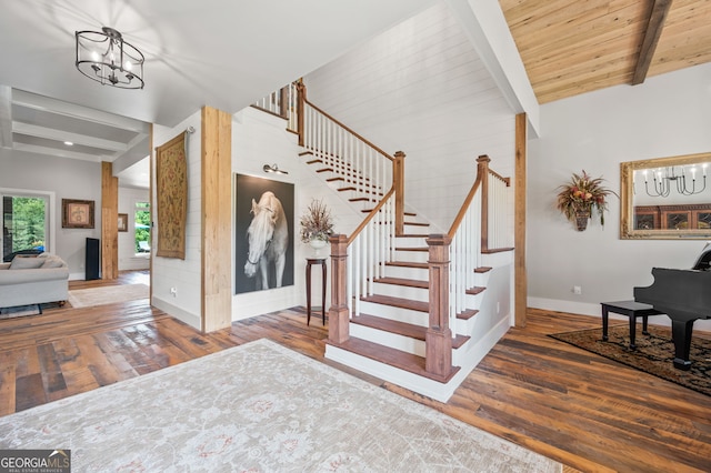 stairway featuring an inviting chandelier, beamed ceiling, wooden ceiling, and wood-type flooring