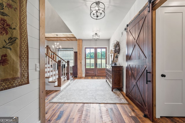 foyer featuring hardwood / wood-style floors, a chandelier, and a barn door