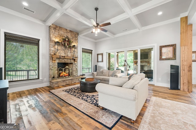 living room with a fireplace, wood-type flooring, ceiling fan, beamed ceiling, and coffered ceiling