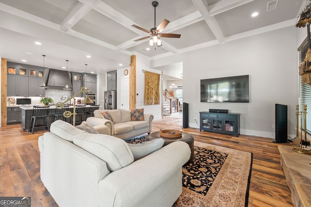 living room with hardwood / wood-style floors, beam ceiling, coffered ceiling, and ceiling fan