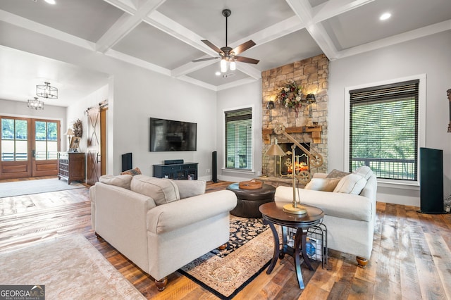 living room with a stone fireplace, hardwood / wood-style floors, and ceiling fan