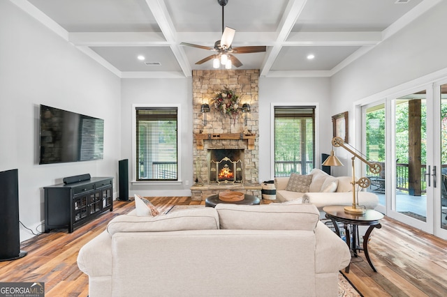 living room with ceiling fan, a fireplace, hardwood / wood-style flooring, and coffered ceiling