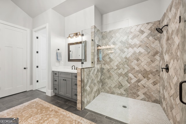 bathroom with vanity, tile patterned flooring, and a tile shower