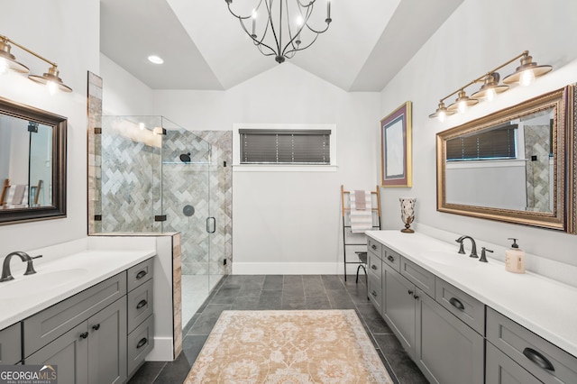 bathroom with tile patterned flooring, a notable chandelier, a shower with door, dual bowl vanity, and vaulted ceiling