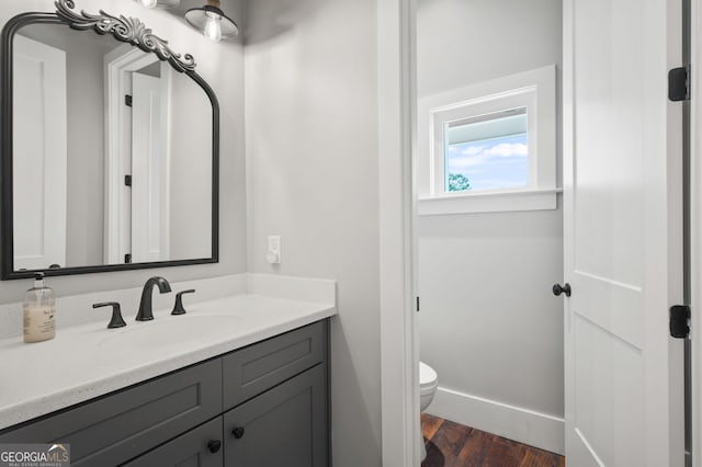 bathroom featuring hardwood / wood-style flooring, toilet, and vanity